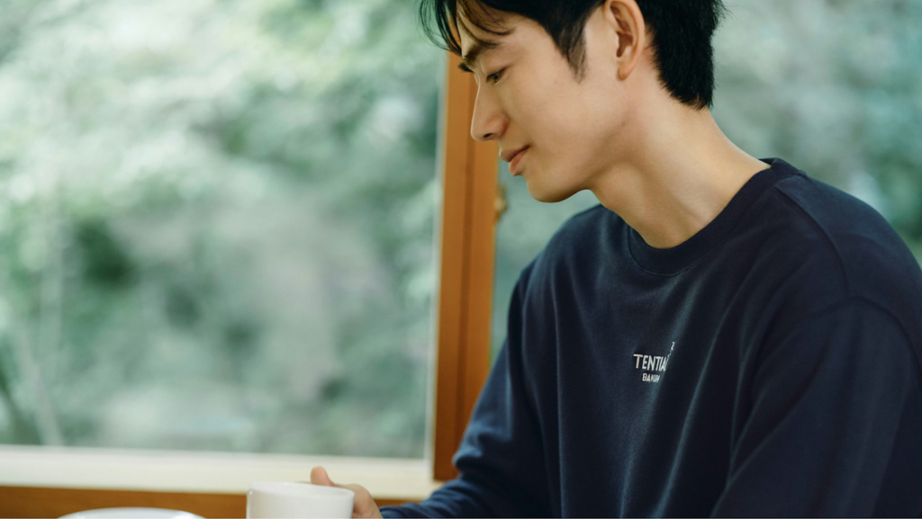 TENTIALのBAKUNEシリーズを着用した男性がカップを持っている様子